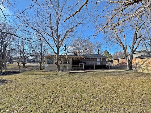 rear view of house with a wooden deck and a yard