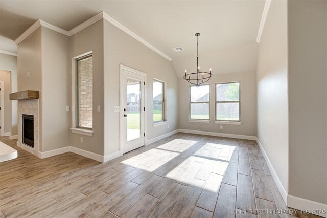 interior space featuring crown molding, a chandelier, and a fireplace