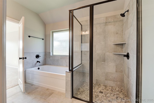 bathroom featuring independent shower and bath and vaulted ceiling