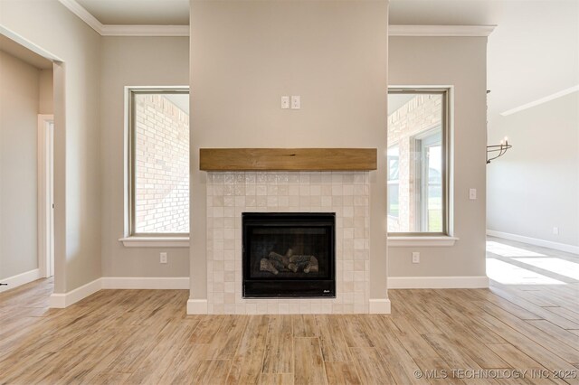 room details featuring hardwood / wood-style floors, ornamental molding, and a tiled fireplace