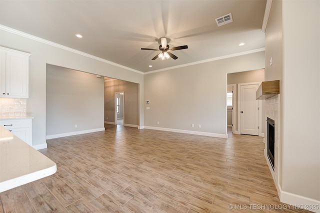 unfurnished living room with ceiling fan, crown molding, and light wood-type flooring