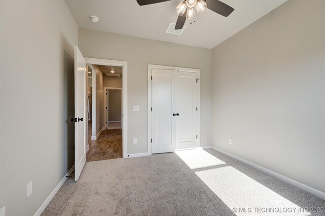 unfurnished bedroom with carpet, a closet, and ceiling fan