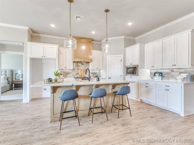 7113 E Princeton St, Broken Arrow, OK 74014 - kitchen featuring stainless steel microwave, white cabinetry, tasteful backsplash, light countertops, and crown molding