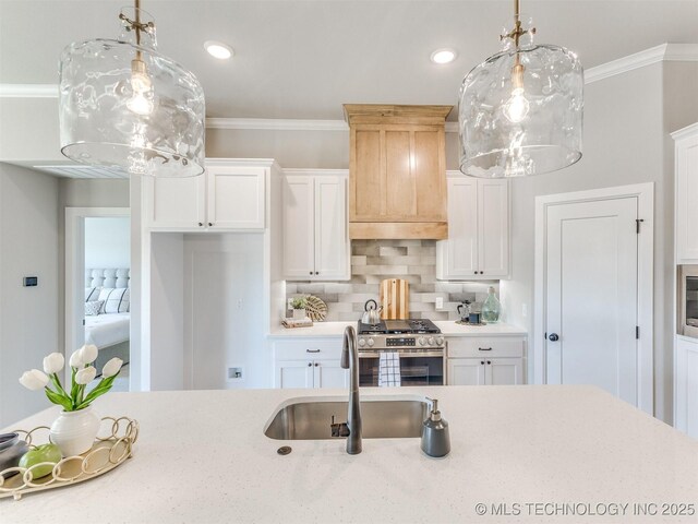 7113 E Princeton St, Broken Arrow, OK 74014 - kitchen featuring stainless steel range with gas stovetop, custom range hood, decorative backsplash, crown molding, and white cabinets