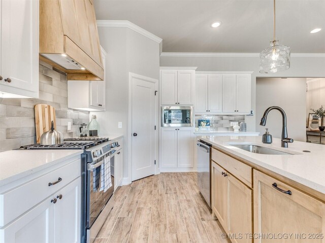 7113 E Princeton St, Broken Arrow, OK 74014 - kitchen featuring appliances with stainless steel finishes, premium range hood, tasteful backsplash, hanging light fixtures, and light wood-style floors