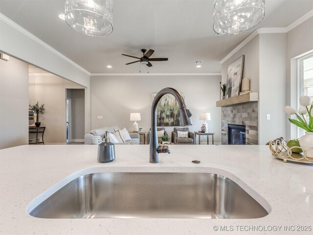 7113 E Princeton St, Broken Arrow, OK 74014 - kitchen with open floor plan, a glass covered fireplace, ornamental molding, recessed lighting, and a ceiling fan
