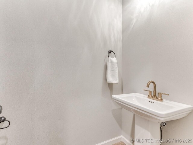 7113 E Princeton St, Broken Arrow, OK 74014 - bathroom featuring baseboards and a sink