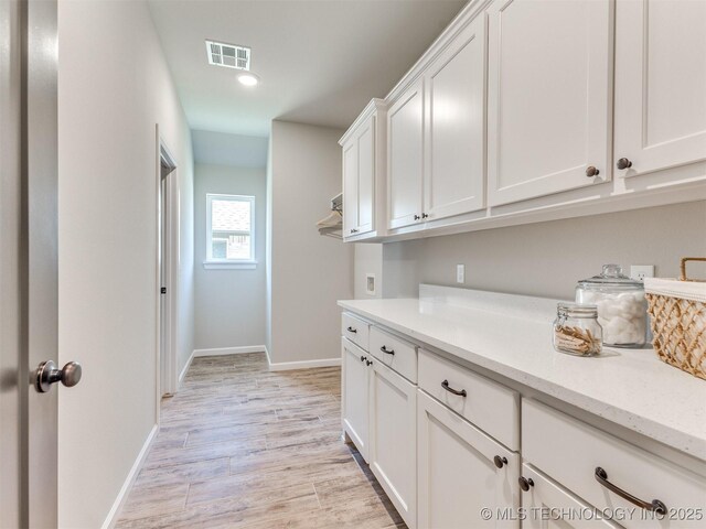 7113 E Princeton St, Broken Arrow, OK 74014 - laundry area with cabinet space and light wood finished floors