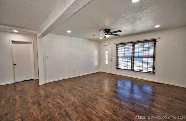 empty room featuring ceiling fan, dark hardwood / wood-style flooring, and a textured ceiling