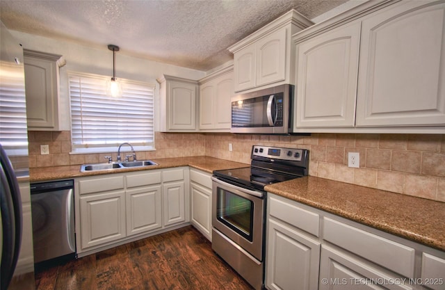 kitchen featuring washer / dryer, sink, white cabinets, dark hardwood / wood-style floors, and stainless steel appliances