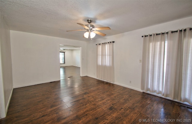 empty room featuring ceiling fan, a textured ceiling, and dark hardwood / wood-style flooring