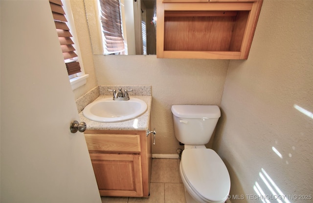 bathroom with vanity, toilet, and tile patterned floors