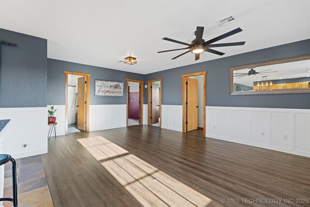 unfurnished living room with dark hardwood / wood-style flooring and ceiling fan