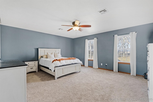 bedroom with ceiling fan and light carpet