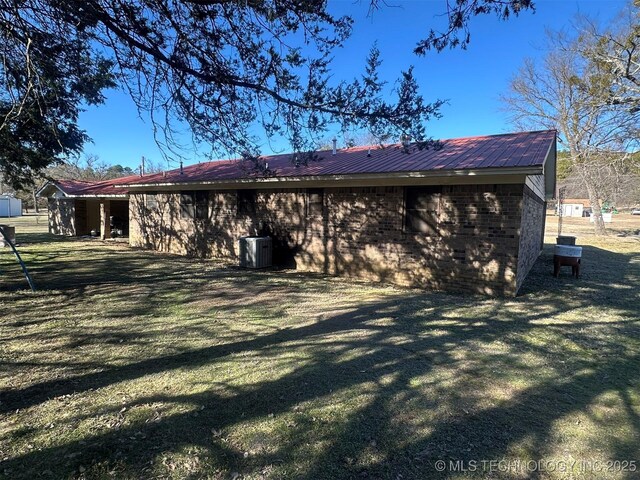 back of house featuring central AC and a yard