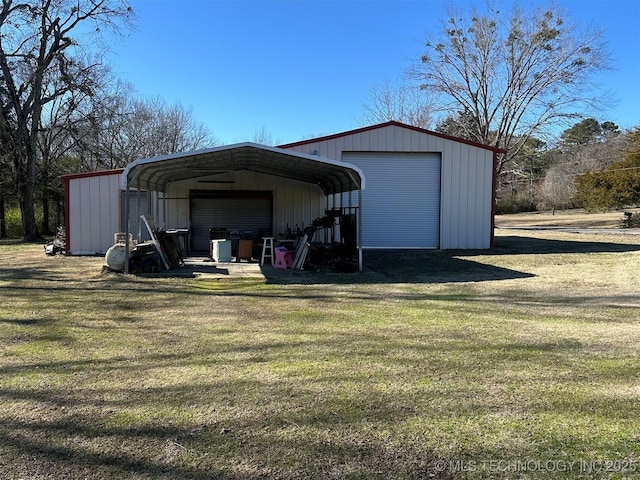 view of outbuilding with a garage, a lawn, and a carport