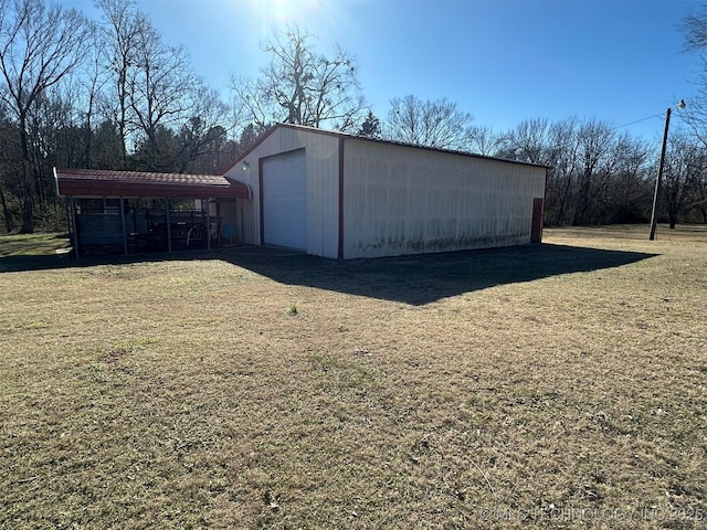 view of outbuilding with a garage, a yard, and a carport