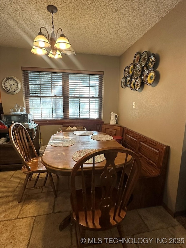 dining area with an inviting chandelier and a textured ceiling