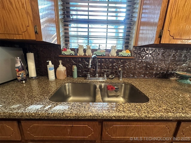 kitchen with sink, backsplash, and dark stone counters