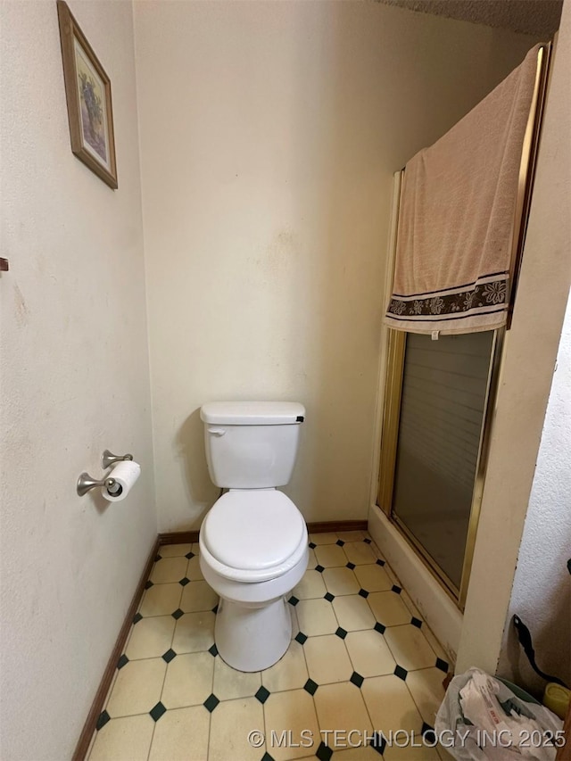 bathroom featuring toilet and walk in shower