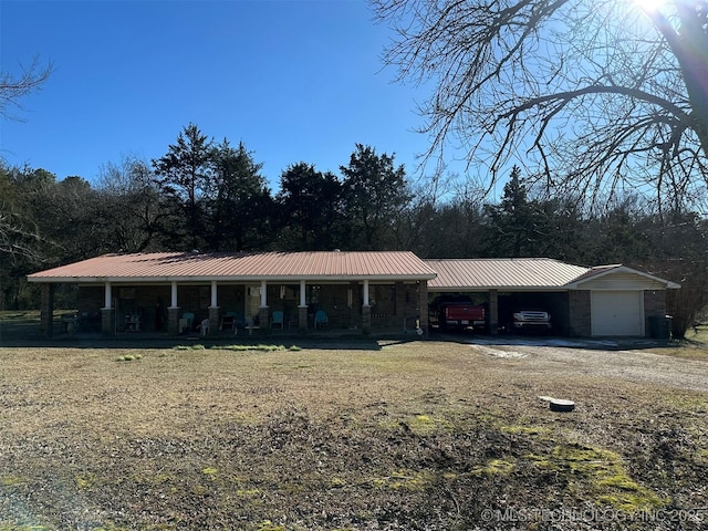 single story home with a carport, a porch, and a garage