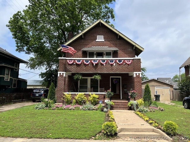 view of front of house featuring a porch, a front lawn, and a shed