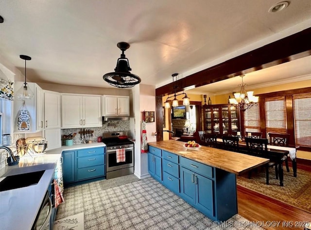 kitchen with wood counters, sink, hanging light fixtures, stainless steel electric range, and white cabinets