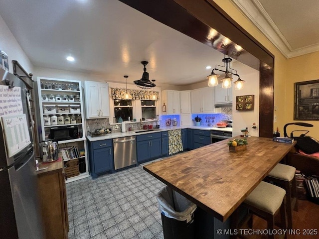 kitchen featuring blue cabinetry, stainless steel dishwasher, white cabinetry, and hanging light fixtures