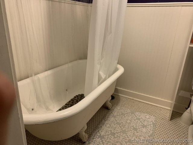 bathroom with a tub to relax in and tile patterned flooring