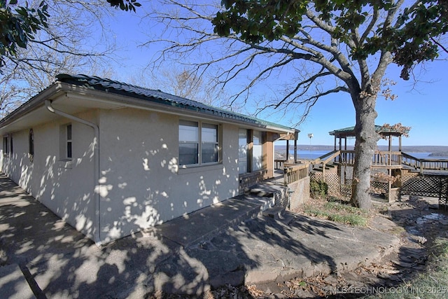 view of side of property with a deck with water view