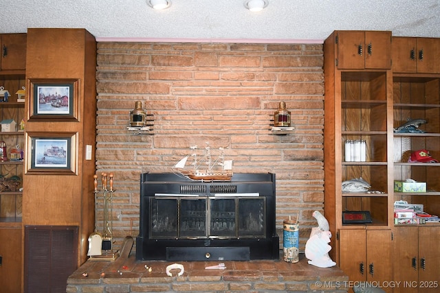 room details featuring a stone fireplace and a textured ceiling