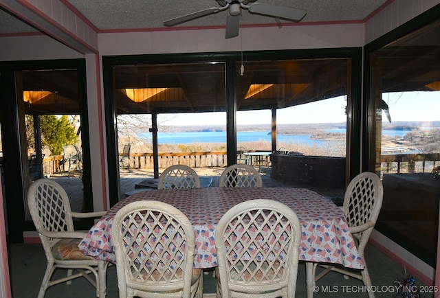 sunroom with a water view, ceiling fan, and a healthy amount of sunlight