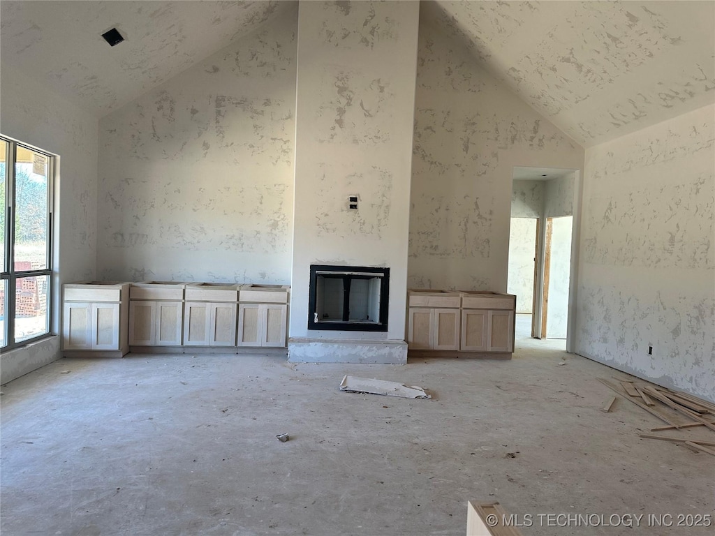 unfurnished living room with a healthy amount of sunlight and high vaulted ceiling