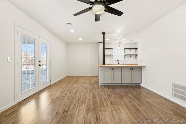 interior space featuring french doors, tasteful backsplash, light wood-type flooring, ceiling fan, and butcher block countertops