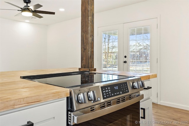 kitchen with light wood-type flooring, ceiling fan, french doors, and stainless steel electric range oven