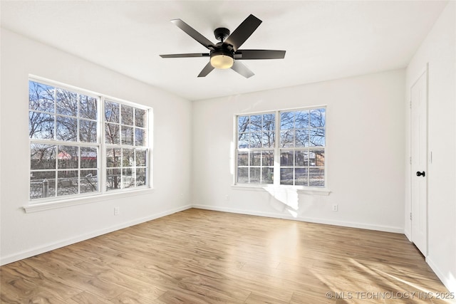 spare room featuring light hardwood / wood-style floors, a wealth of natural light, and ceiling fan