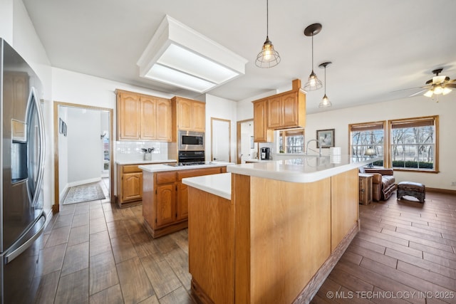 kitchen with a center island, decorative light fixtures, kitchen peninsula, backsplash, and stainless steel appliances