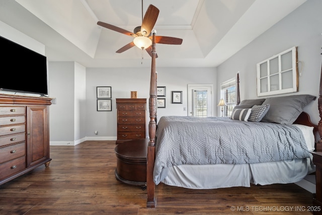 bedroom featuring ceiling fan, a tray ceiling, dark hardwood / wood-style flooring, and crown molding