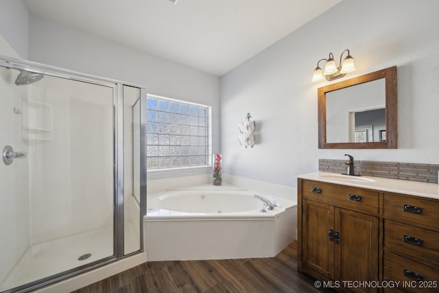 bathroom with wood-type flooring, shower with separate bathtub, and vanity