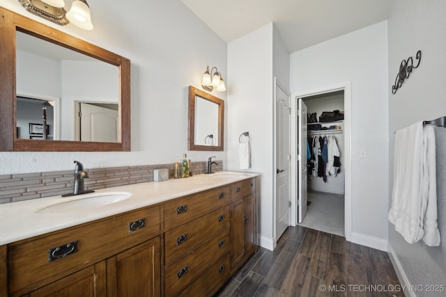 bathroom with decorative backsplash, hardwood / wood-style floors, and vanity