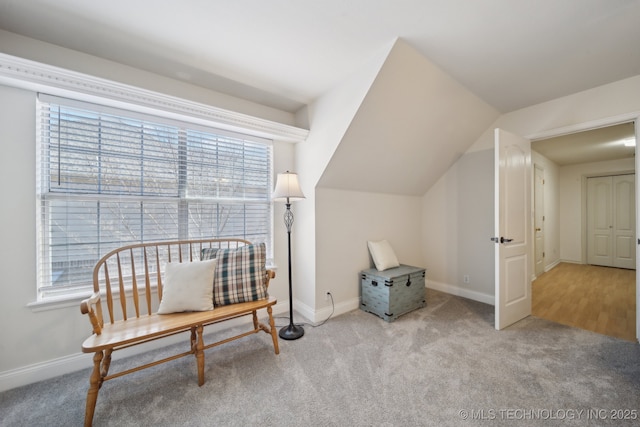 living area featuring light colored carpet, plenty of natural light, and lofted ceiling