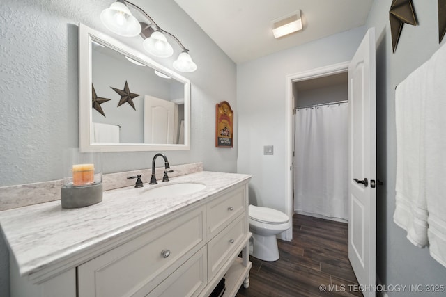 bathroom featuring hardwood / wood-style floors, toilet, and vanity