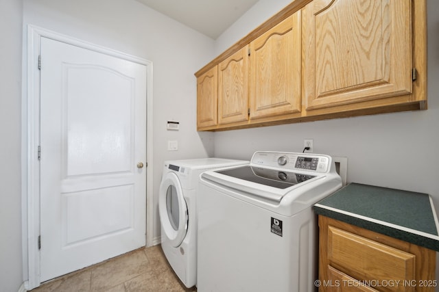 washroom with washing machine and dryer, light tile patterned floors, and cabinets