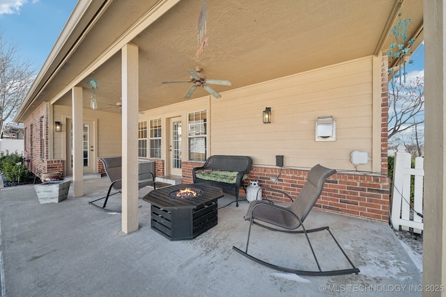 view of patio with ceiling fan and an outdoor living space with a fire pit