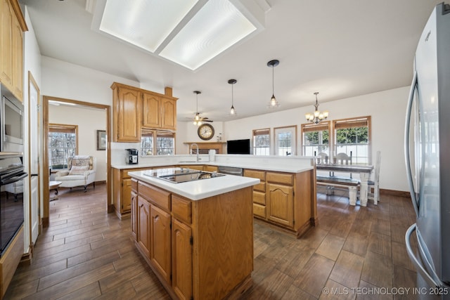 kitchen featuring a center island, stainless steel appliances, sink, hanging light fixtures, and kitchen peninsula