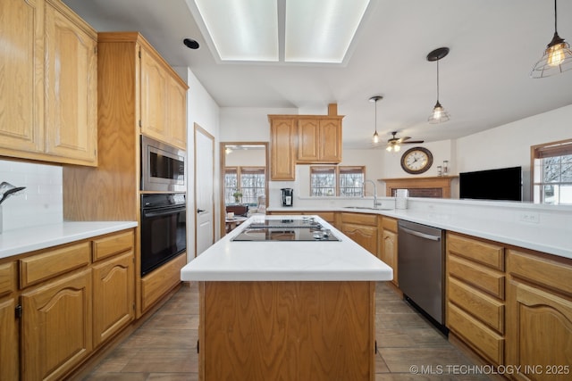 kitchen with black appliances, a center island, hanging light fixtures, sink, and kitchen peninsula