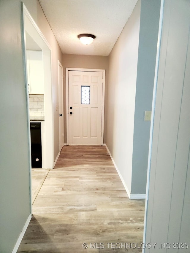 doorway featuring light hardwood / wood-style floors and a textured ceiling