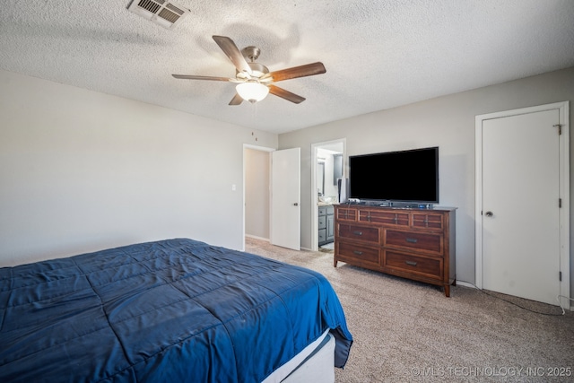 bedroom with light colored carpet, a textured ceiling, ceiling fan, and ensuite bath