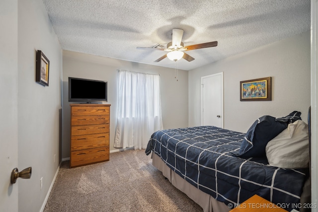 carpeted bedroom featuring ceiling fan and a textured ceiling