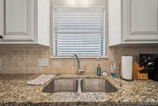 kitchen featuring white cabinetry, sink, decorative backsplash, and light stone countertops